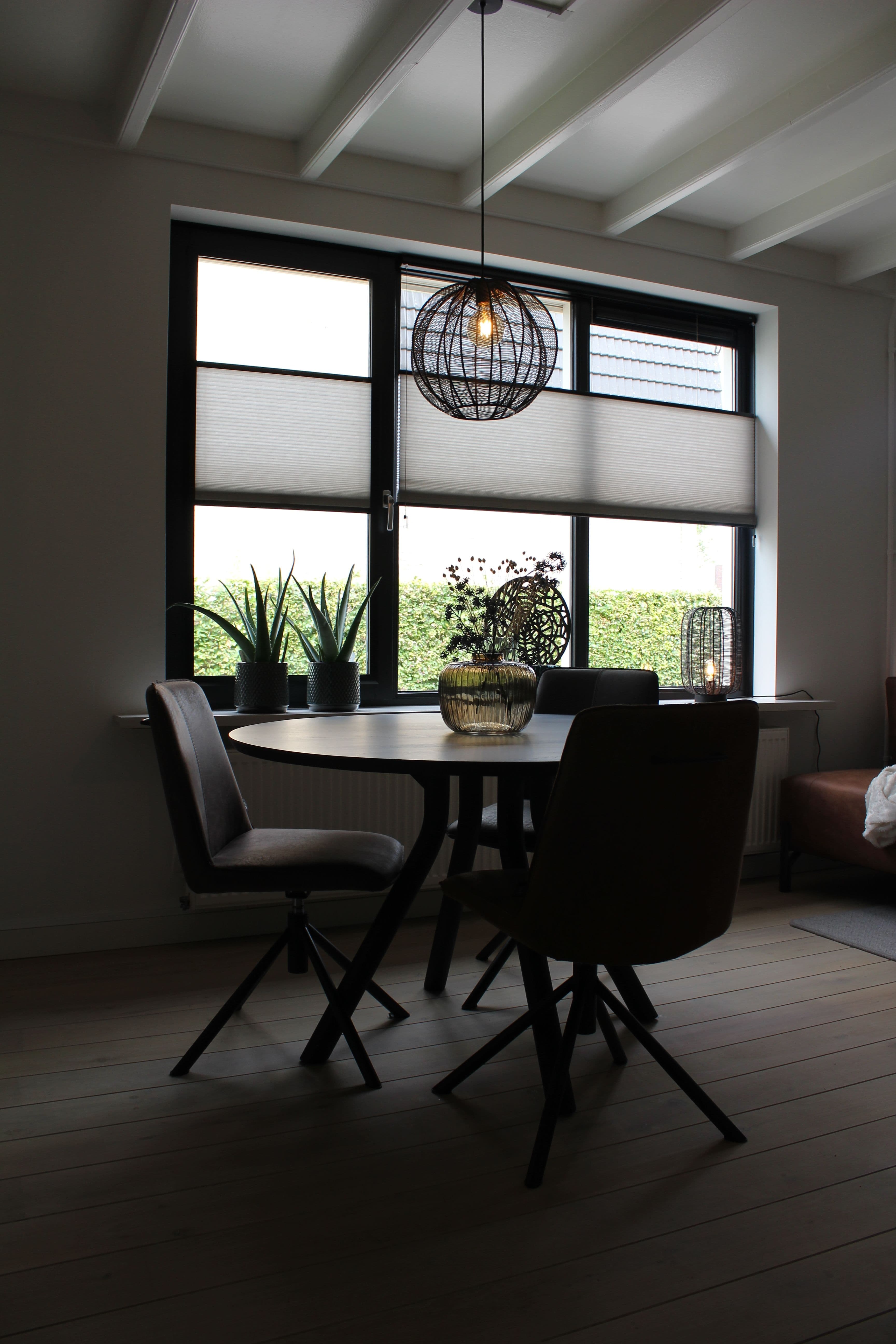 Eethoek in een woning met een hanglamp boven de tafel
